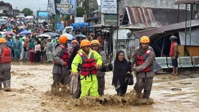Sejumlah polisi membantu evakuasi warga korban banjir bandang di Sumut.