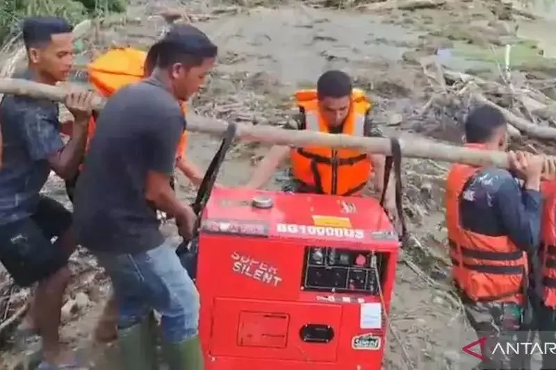Personel TNI AD dan petugas PLN memikul genset ke lokasi bencana di Desa Sikundo, Kecamatan Pante Cermin, Kabupaten Aceh Barat, Sabtu (3/1/2026).