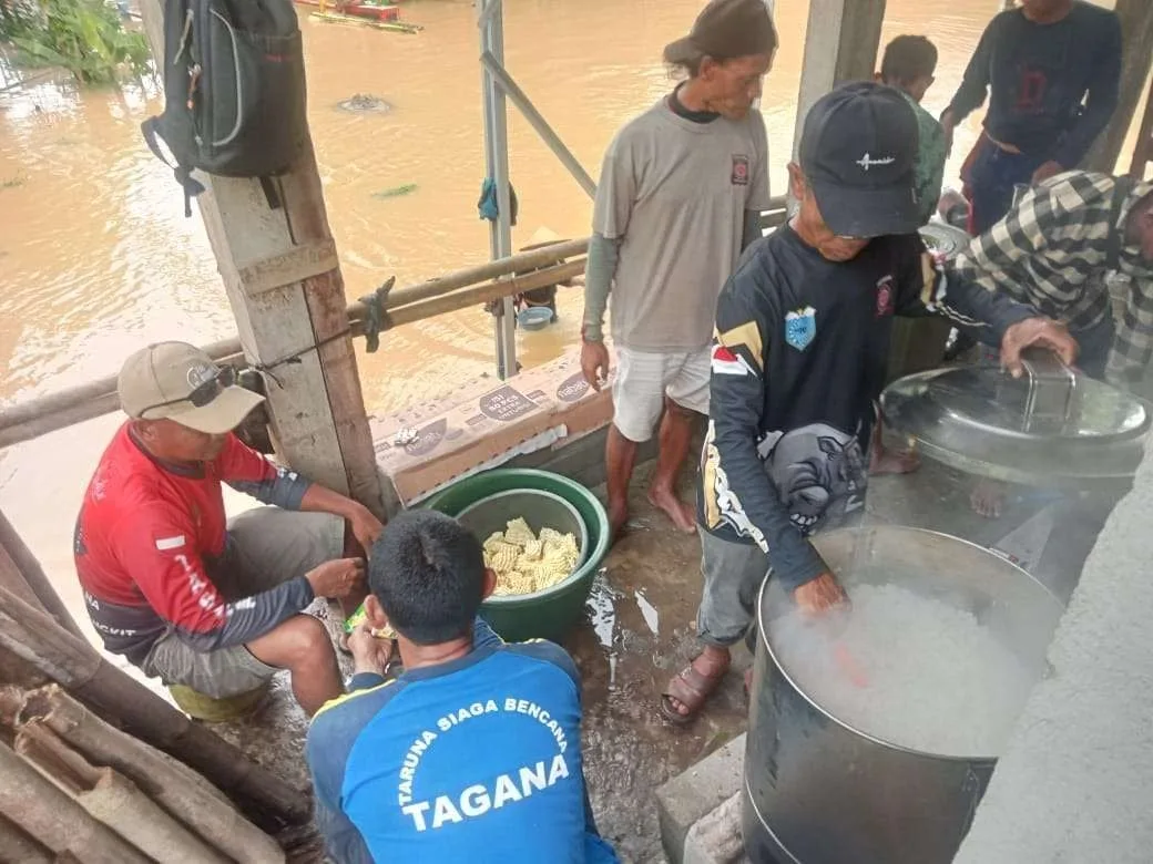 Petugas Taruna Siaga Bencana (TAGANA) menyiapkan makanan siap saji bagi warga terdampak banjir di Kabupaten Pandeglang, Banten.
